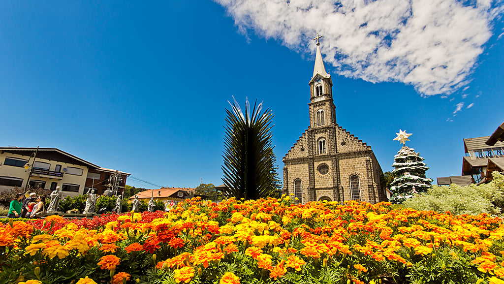 Foto de um campo de flores em frente a catedral de Gramado