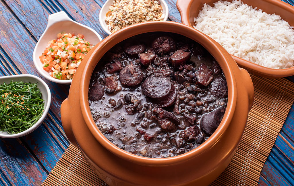A feijoada no Rio de Janeiro é feita com feijão-preto e servida com arroz, farofa e couve