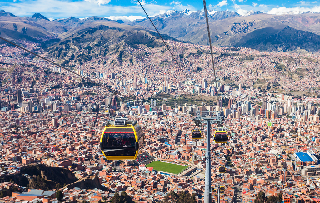 Os teleféricos em La Paz oferecem visão ampla para a cidade que tem o grande estádio Hernando Siles no centro e o Monte Illimani ao fundo 