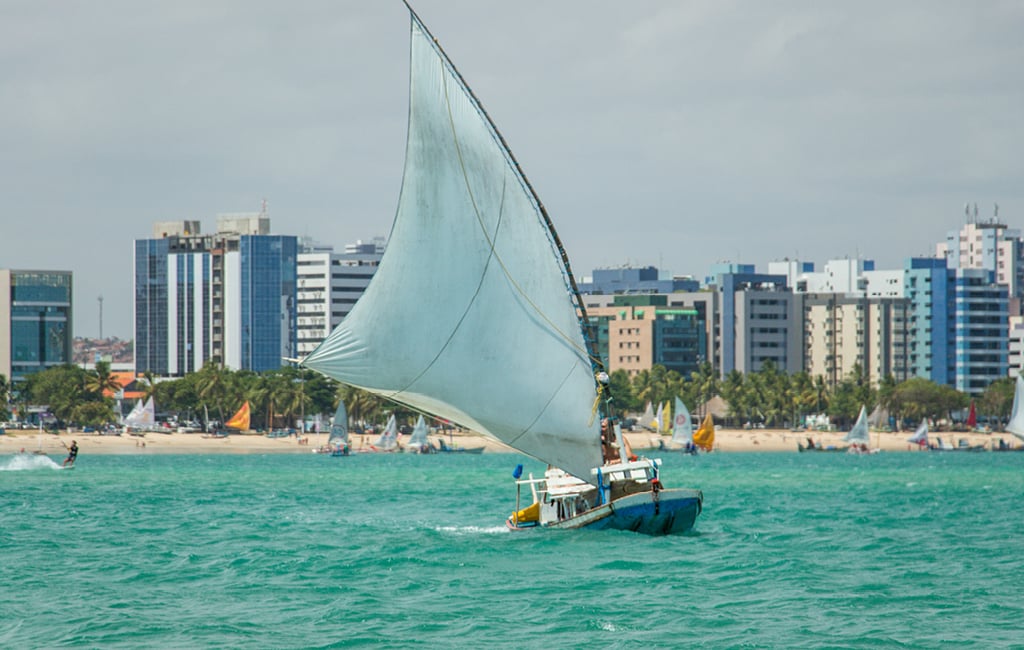 Turistas chegam a bordo de jangadas às praias naturais de Maceió