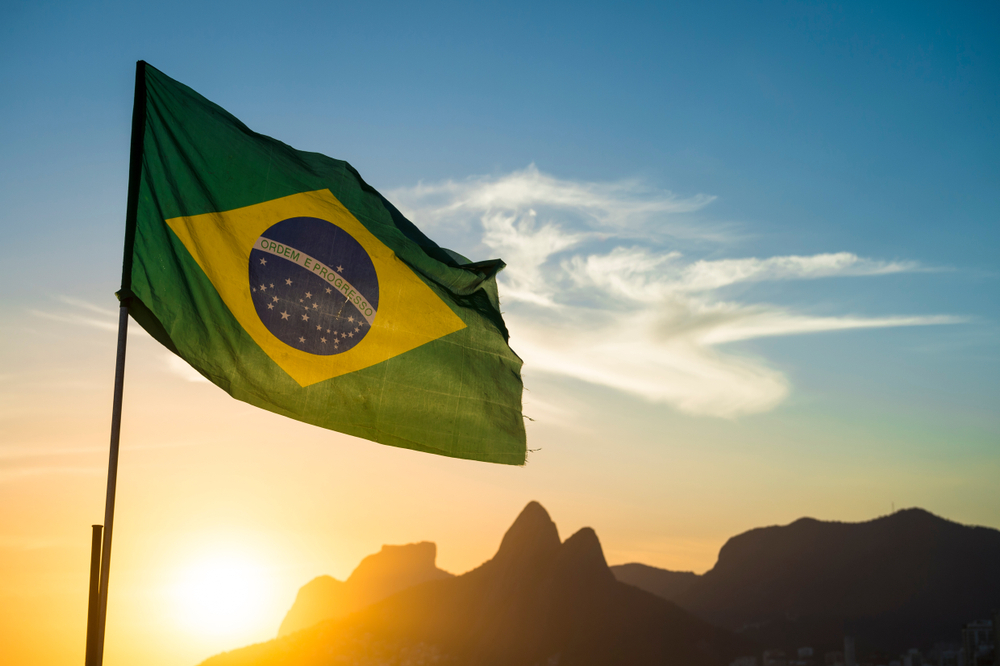 Tipos de turismo para fazer no Brasil: ecoturismo, cultural e gastronômico | Bandeira do Brasil ao pôr do sol pôr do sol na Praia de Ipanema, no Rio de Janeiro | Conexão123