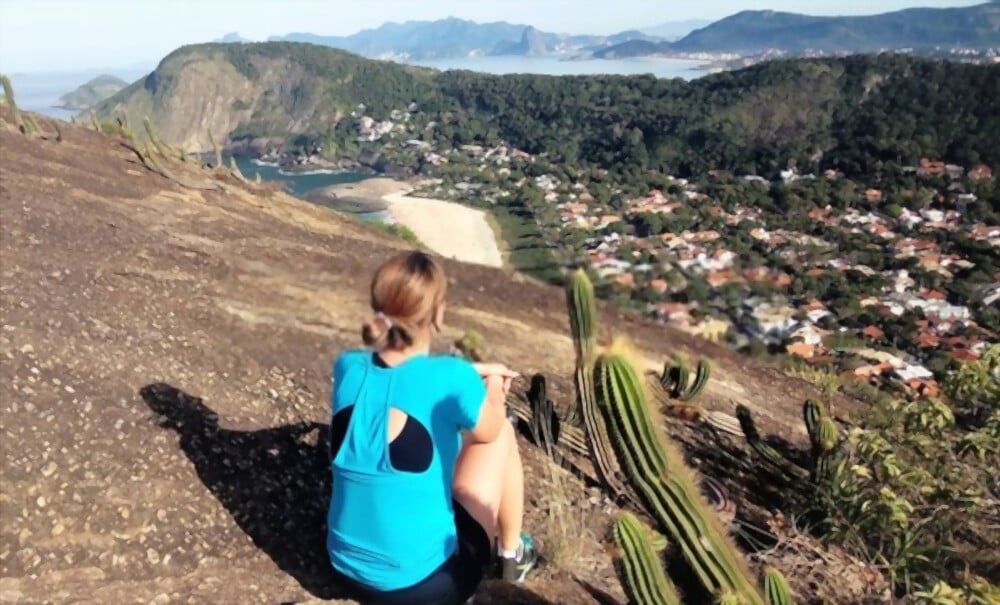 Três trilhas no Rio de Janeiro com vistas de tirar o fôlego | Mulher sentada no Costão de Itacoatiara | Conexão123