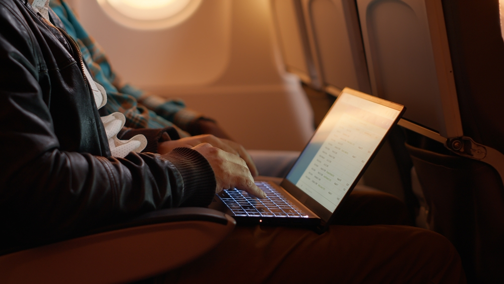 Celular no avião: dicas de como utilizar seu aparelho eletrônico em voos | Pessoa editando documentos no voo | Conexão123