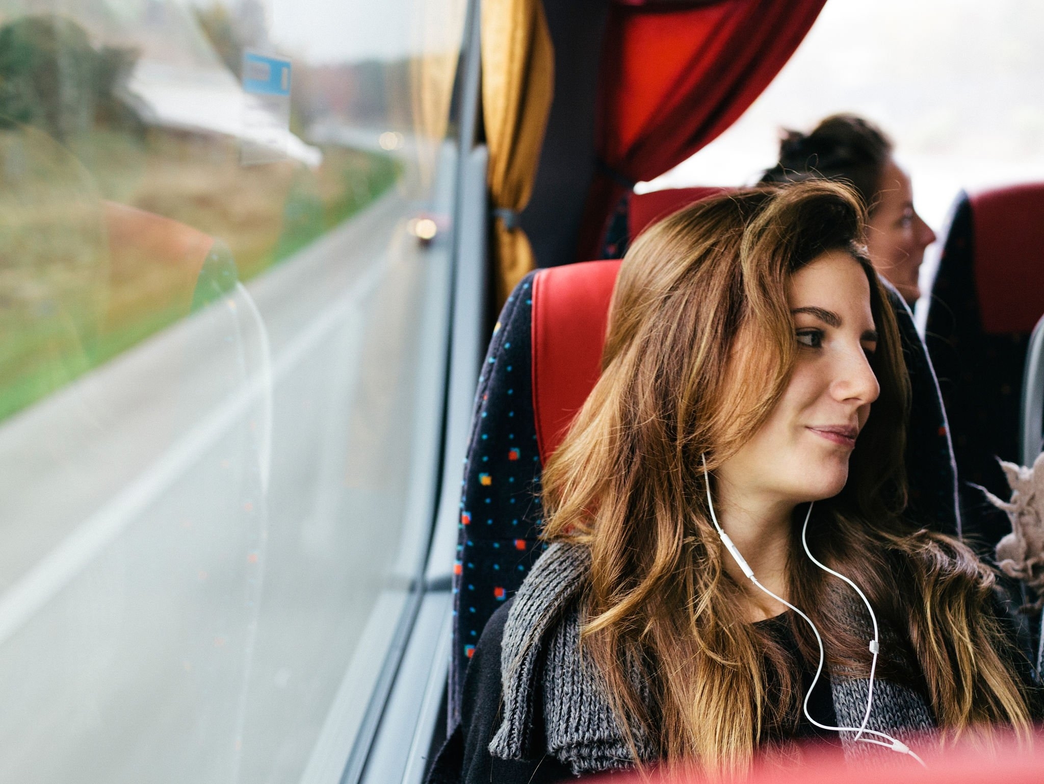 Conheça lugares para viajar de ônibus pelo Brasil | Mulher na janela do ônibus | Conexão123