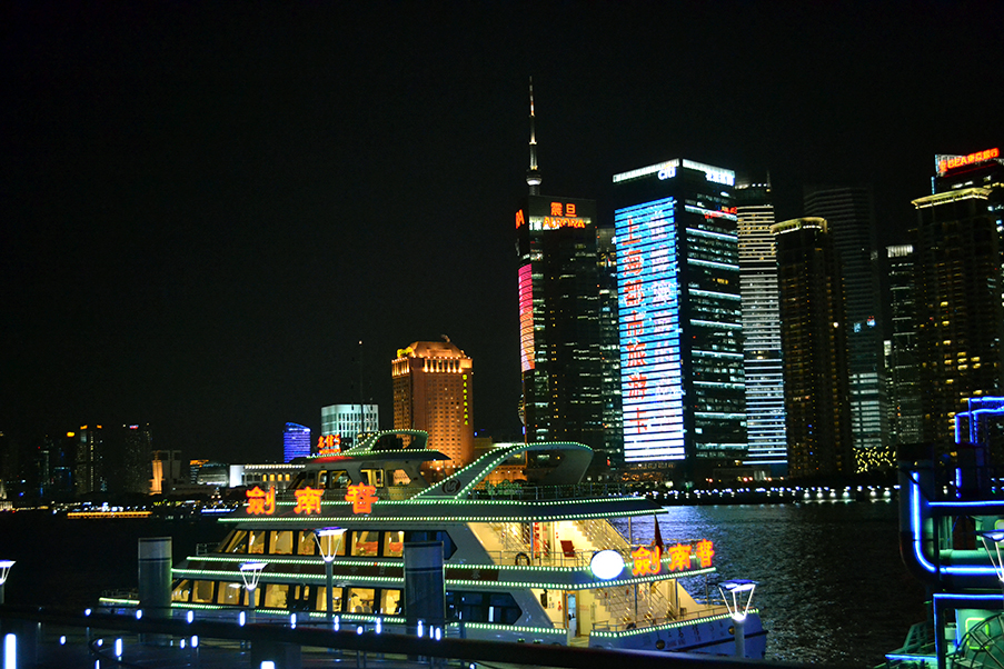 Durante a noite, os barcos dão um show de iluminação nas águas do Rio Huangpu, em Xangai
