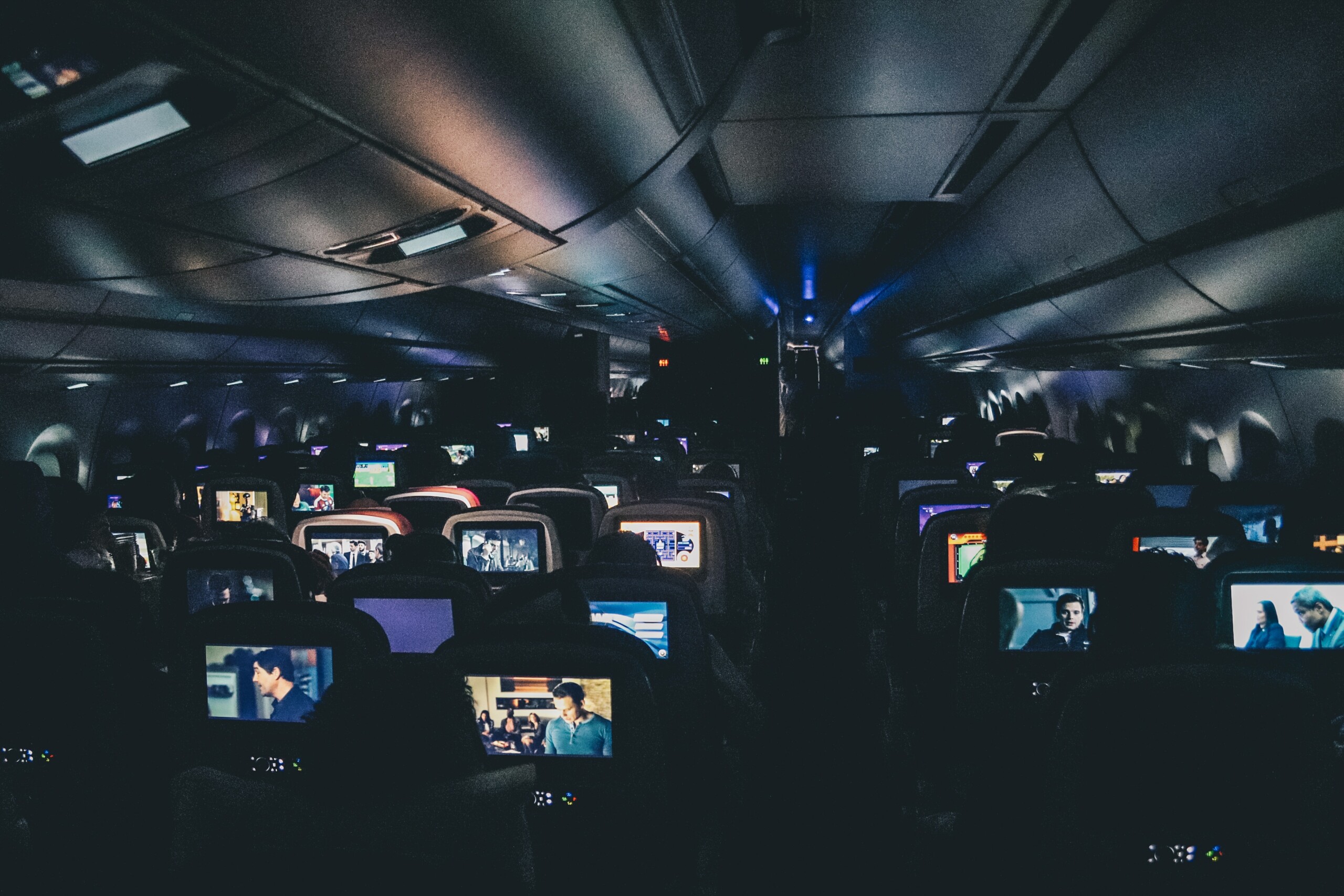 Dicas para quem vai viajar sozinho de ônibus, avião ou carro | Poltronas de avião reproduzindo mídia para os passageiros | Conexão123