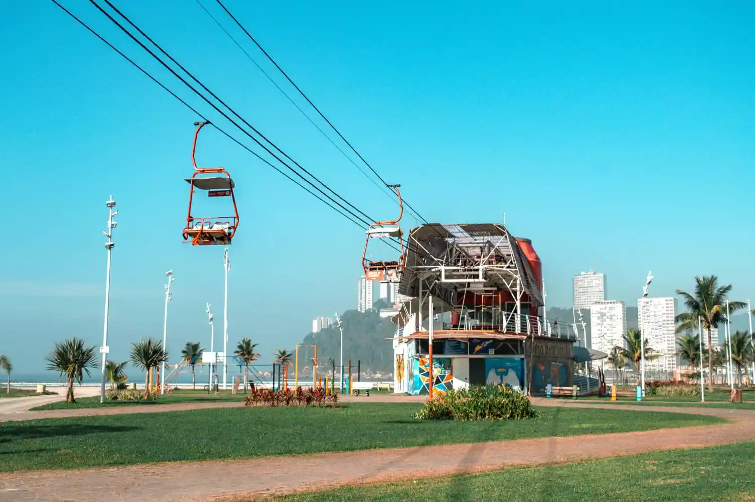 Conheça os teleféricos mais incríveis do Brasil | Vista do alto da Baía de São Vicente com as cadeiras vermelhas do Teleférico de São Vicente | Conexão123