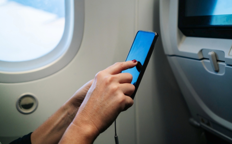 FBI Alerta: carregar o celular no aeroporto traz riscos ao usuário | Usuário utilizando celular durante o voo | Conexão123