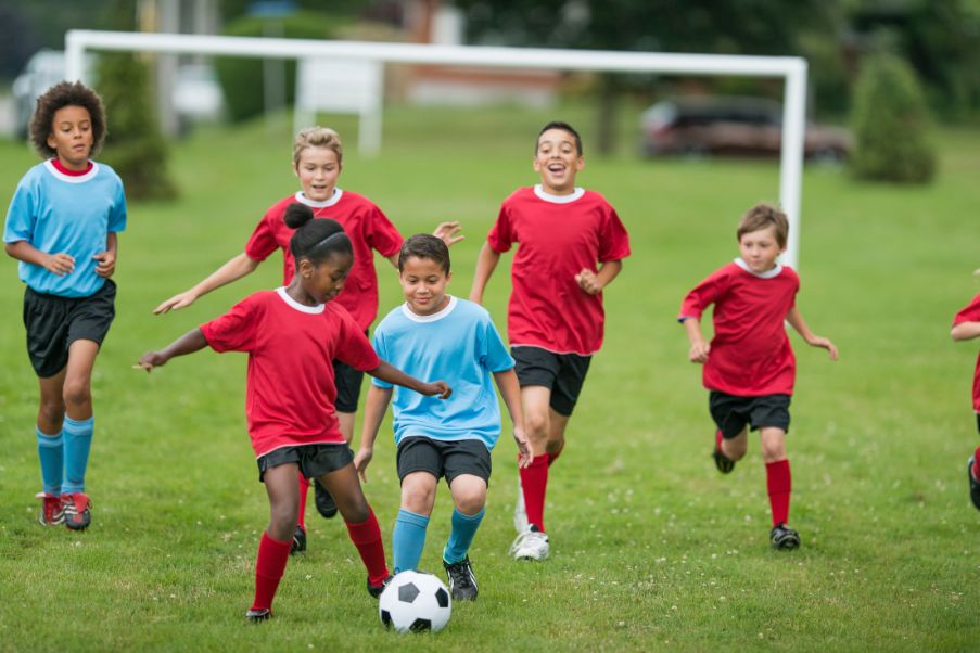 Dia do Futebol: três destinos para os apaixonados pelo esporte | Crianças se divertindo e jogando futebol juntas | Conexão123